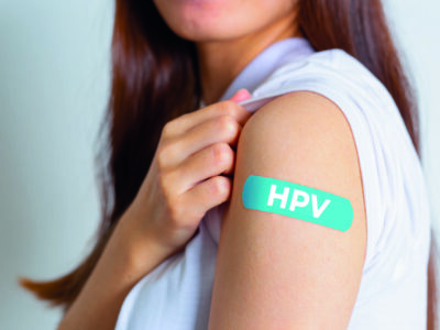 HPV (Human Papillomavirus) Teenager woman showing off an blue bandage after receiving the HPV vaccine.viruses Some strains infect genitals and can cause cervical cancer. Woman health concept.