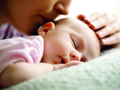 Mother kissing her sleeping baby